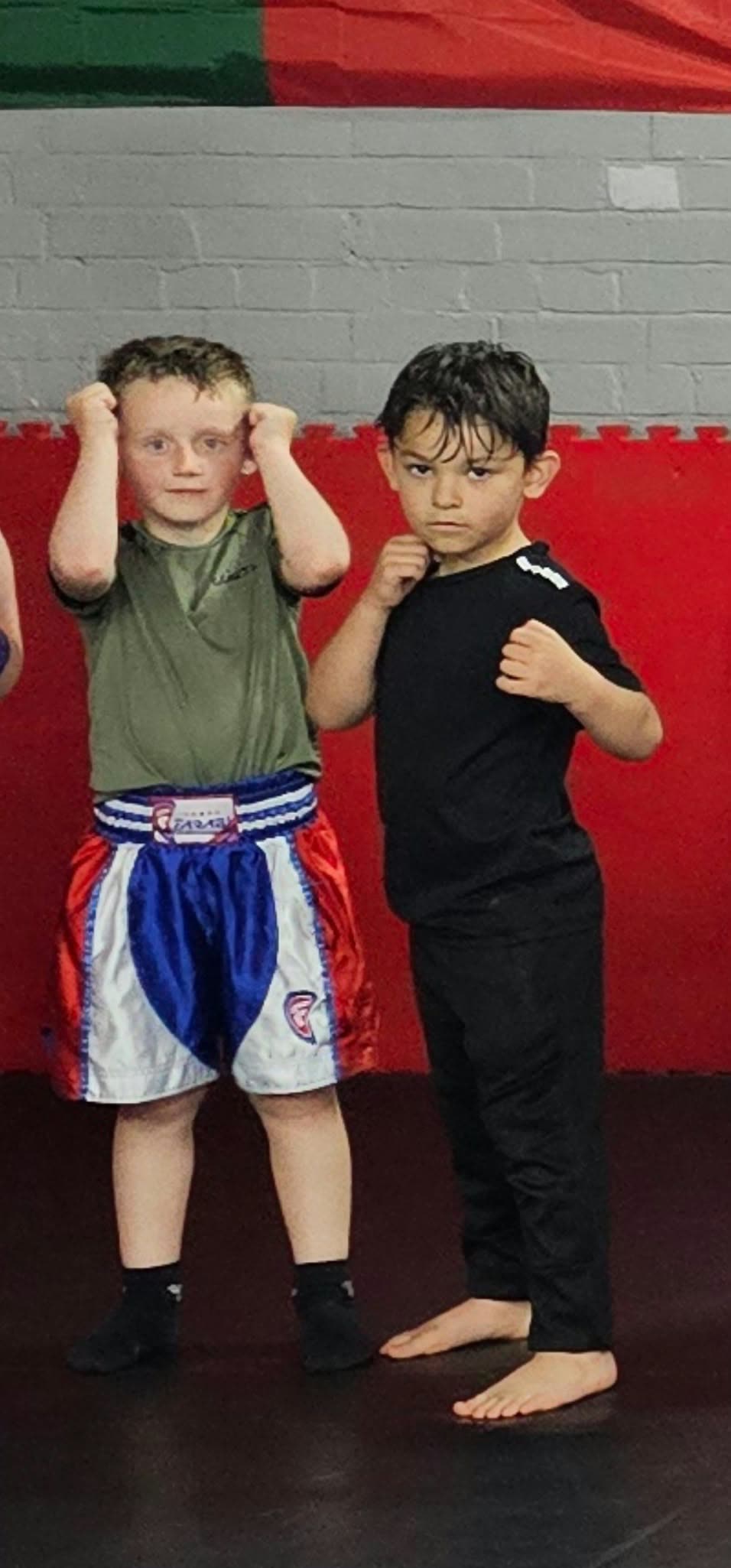 Two young boys in guard stance on the mats at Union Thai